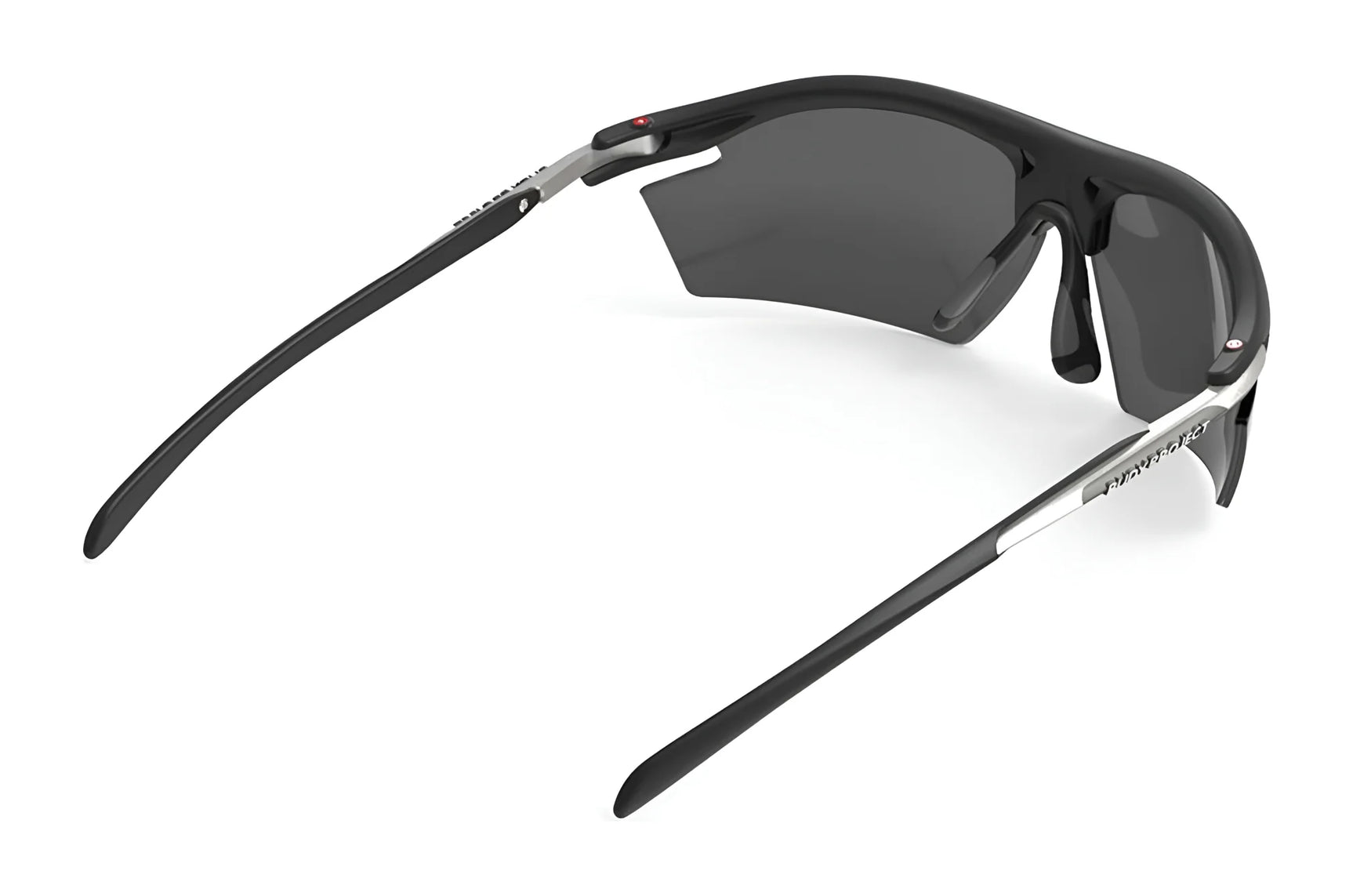 The Rudy Project Rydon Sunglasses by Rudy Project are black wraparound sports shades with dark lenses, shown from the rear on a white background. Adjustable anti-slip nosepads ensure a secure fit during intense activities. The Rudy Project Rydon Sunglasses by Rudy Project are black wraparound sports shades with dark lenses, shown from the rear on a white background. Adjustable anti-slip nosepads ensure a secure fit during intense activities.