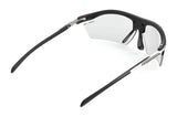 Angled view of Rudy Project Rydon Sunglasses in black with clear lenses, adjustable anti-slip nosepads, and "Rudy Project" branding on the right arm.