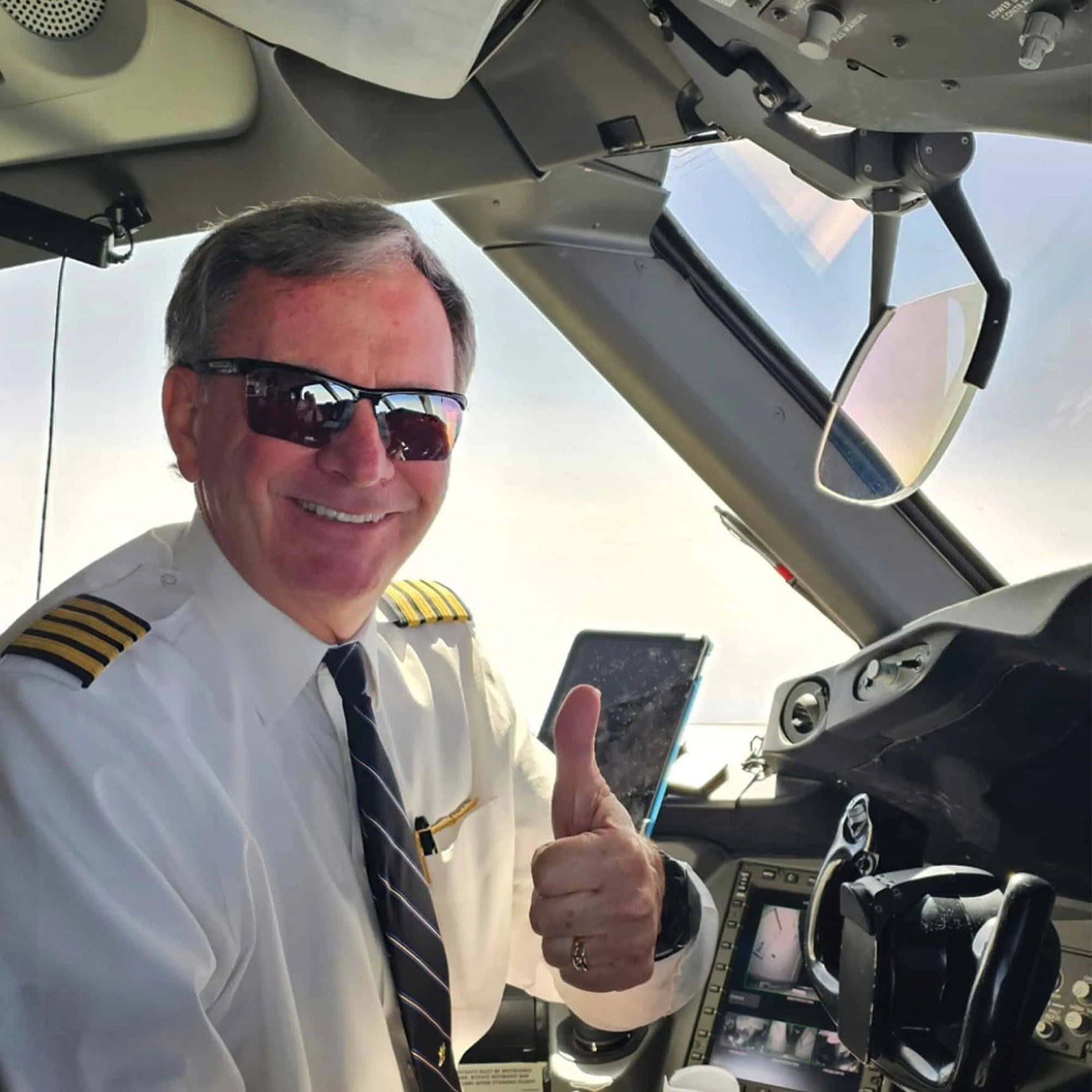 In the airplane cockpit, a pilot in uniform gives a thumbs up while sporting Scheyden CIA GRABBER Sunglasses with stylish RSR lenses and a TR90 composite frame. In the airplane cockpit, a pilot in uniform gives a thumbs up while sporting Scheyden CIA GRABBER Sunglasses with stylish RSR lenses and a TR90 composite frame.